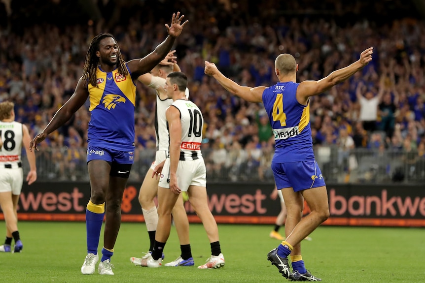 Dom Sheed holds both his arms out and Nic Naitanui moves to high-five him