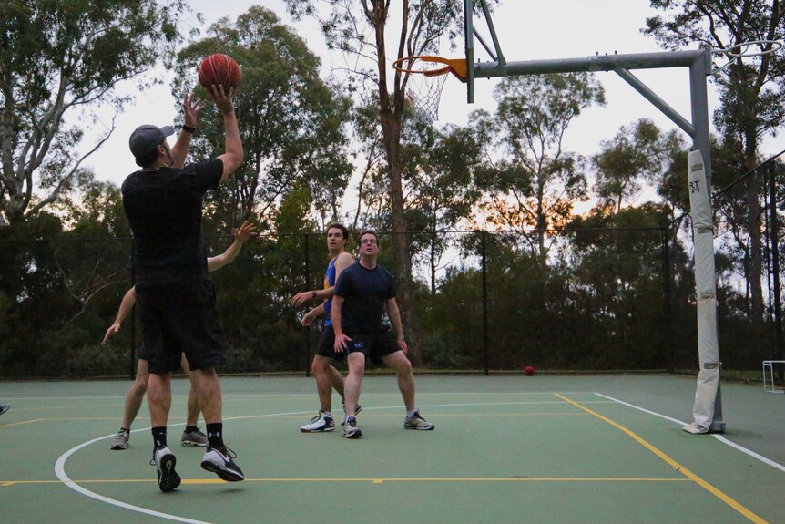 Ed Husic takes a shot in a politicians' basketball game.
