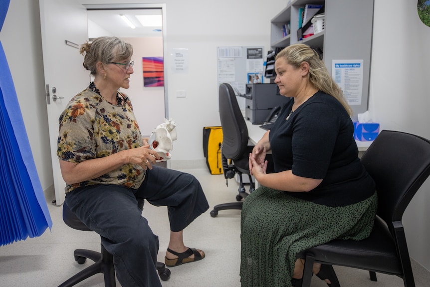 Two women speaking in a medical clinic.