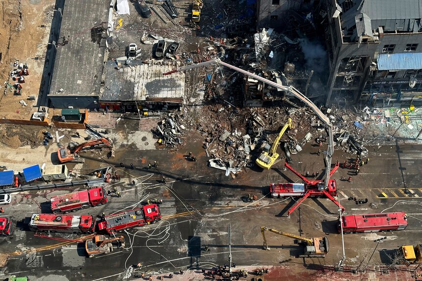 Firefighters work at the scene of an explosion. Aerial shot.