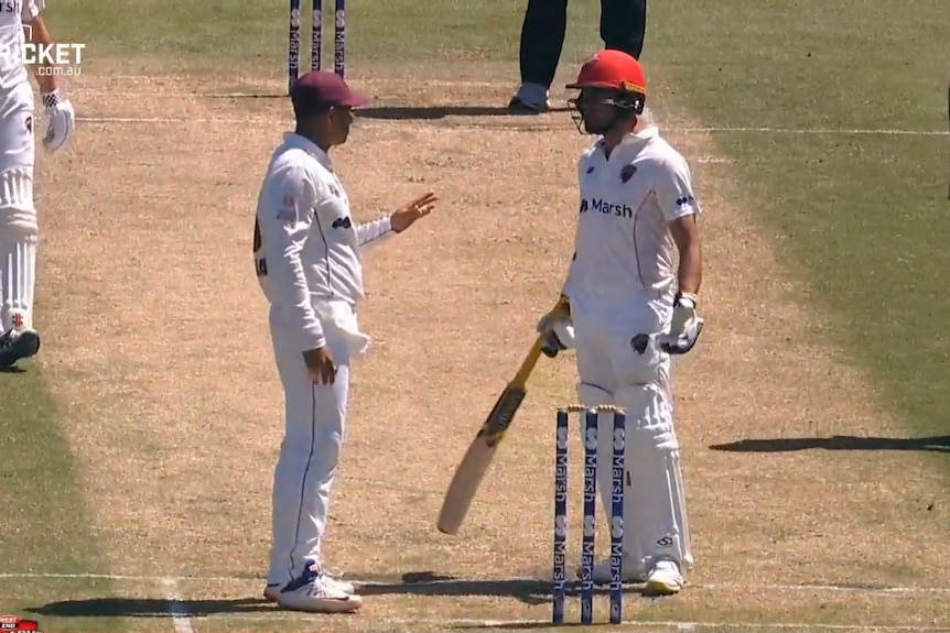 Queensland fielder Usman Khawaja speaks to South Australia batter Jake Weatherald on a cricket pitch in a screenshot.