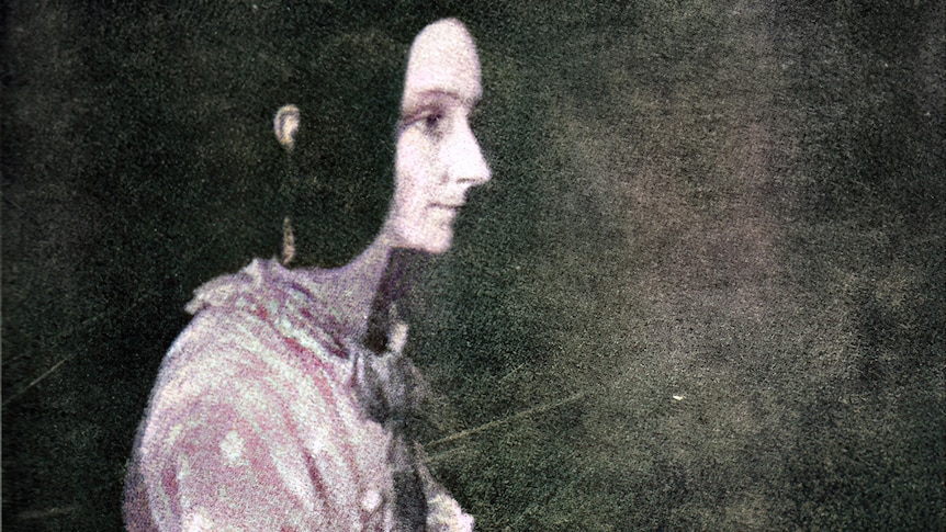 Side portrait of serious thin-lipped dark haired woman playing piano