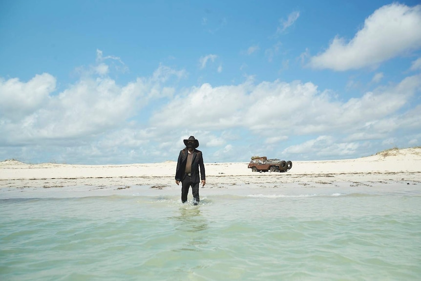 Warwick Thornton walks into the ocean fully dressed in The Beach documentary.