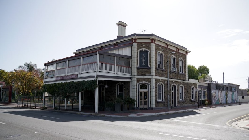 A brown brick building on the corner of a road