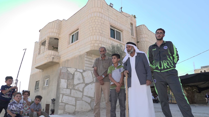 Four members of the Jabarin family stand outside their home in Yatta in the West Bank.