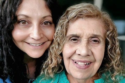 Two women smile at the camera. 