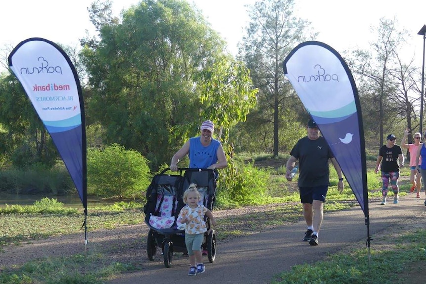 A man jogs towards the finish line of the Longreach Parkrun.