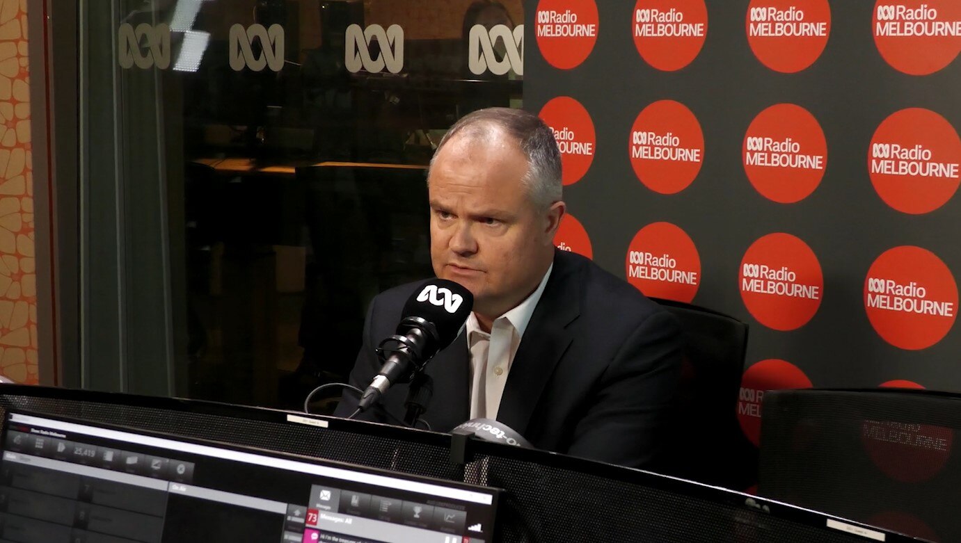 A man sits in front of a microphone