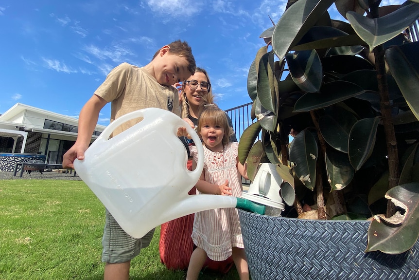 Bliss Grayson and her kids watering a pot plant