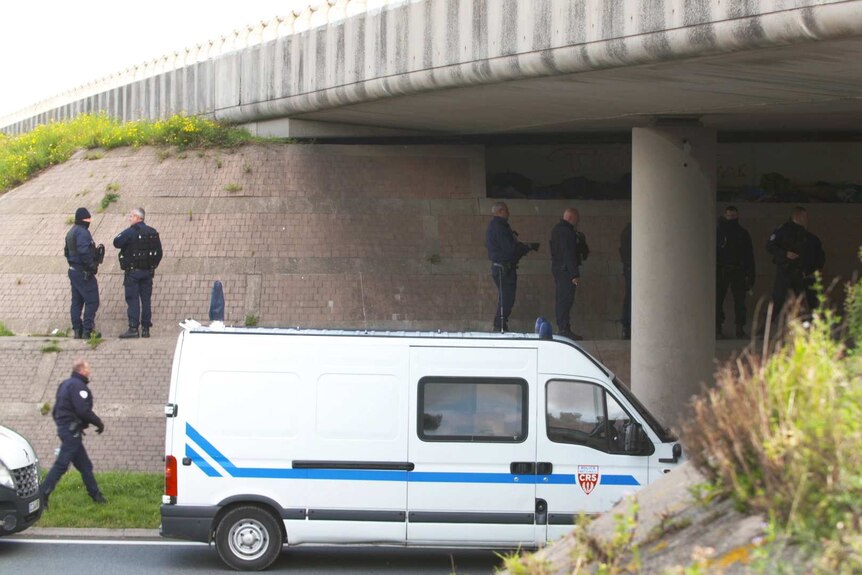 French police standing under a bridge