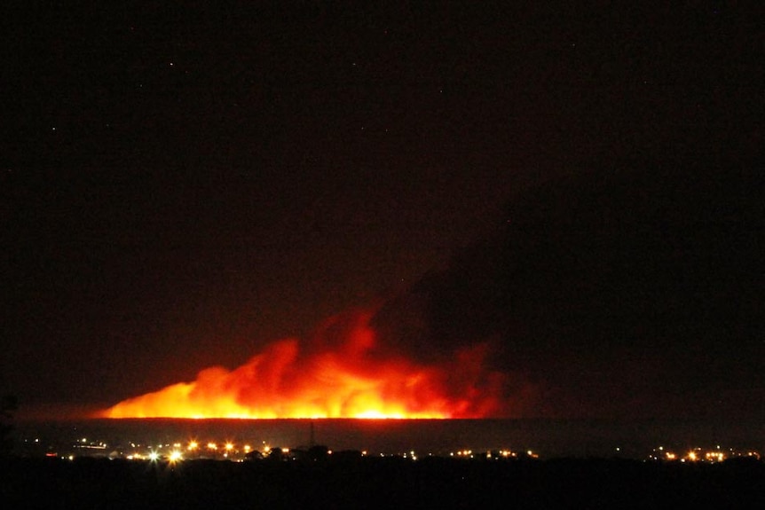 Flames from a large bushfire near Narrawong in south-west Victoria light up the night sky.