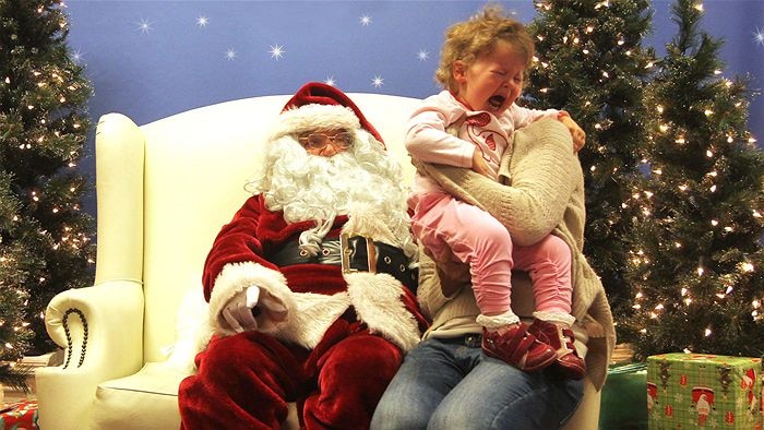 A child cries visiting a department store Santa.