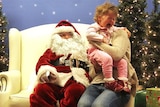 A child cries visiting a department store Santa.