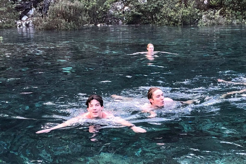 Swimmers at an outdoor waterhole.