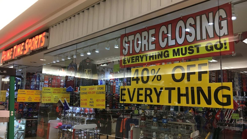 A business has a "Store Closing Everything Must Go!" sign in the shop window.