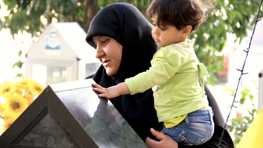 Mother and son at grave in Nabih Chit