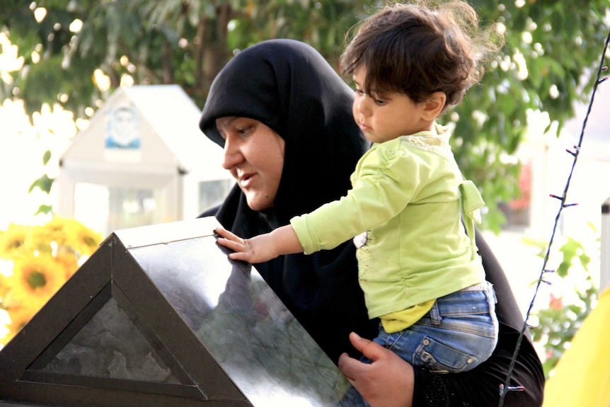 Mother and son at grave in Nabih Chit