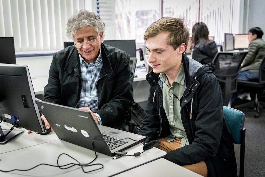 Liam and his teacher in a computer lab.