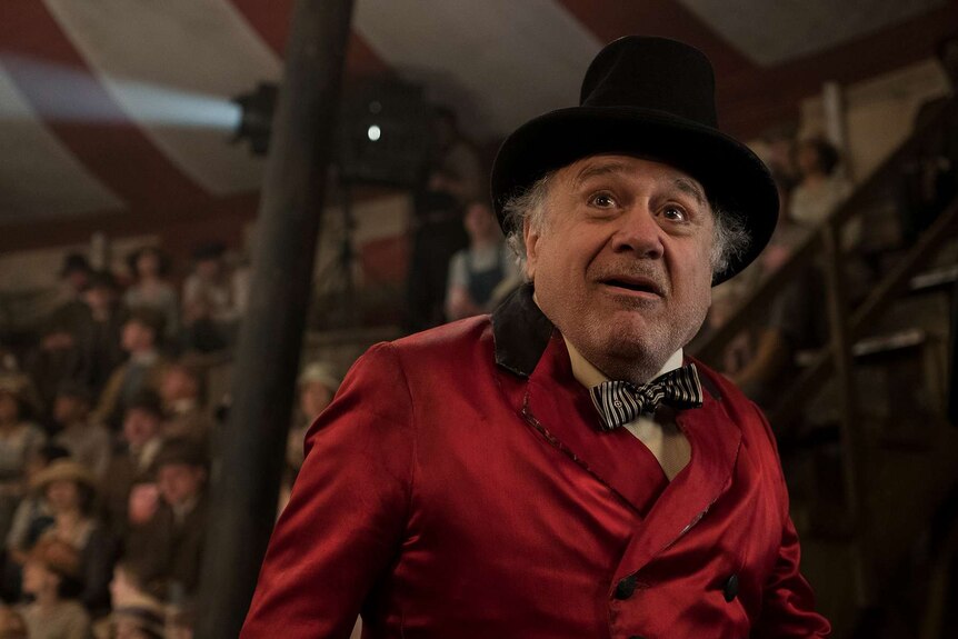 Devito, in a traditional circus ringmaster costume, stares into the middle distance with awe.