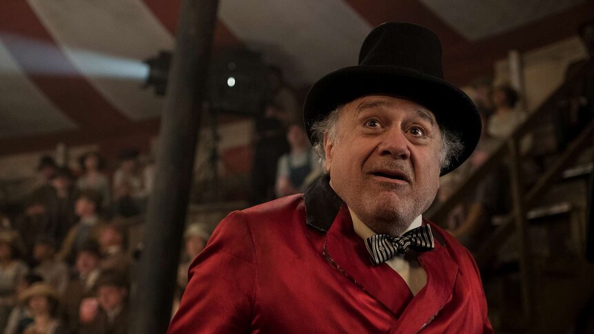 Devito, in a traditional circus ringmaster costume, stares into the middle distance with awe.