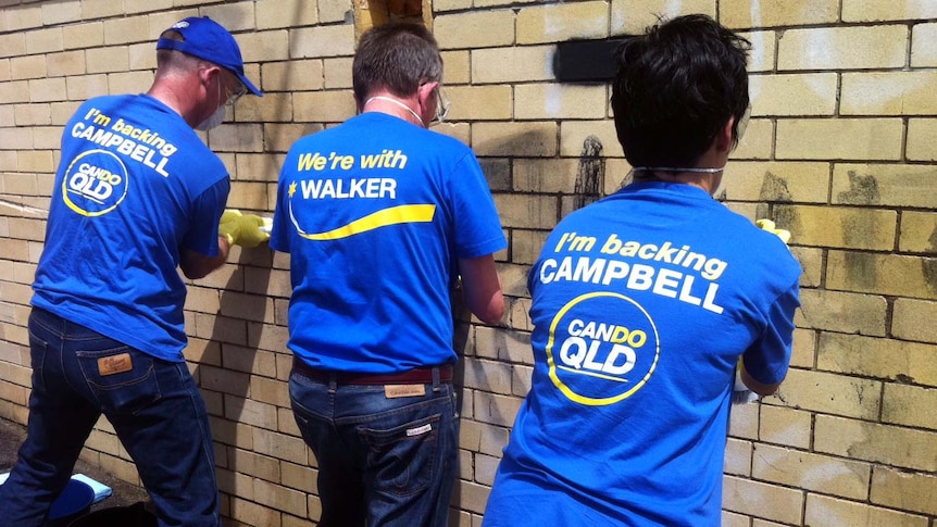 Campbell Newman scrubs graffiti off a wall in the Brisbane suburb of Mansfield