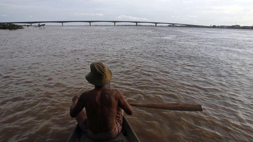 A Cambodian man rows a boat during floods near the Mekong river