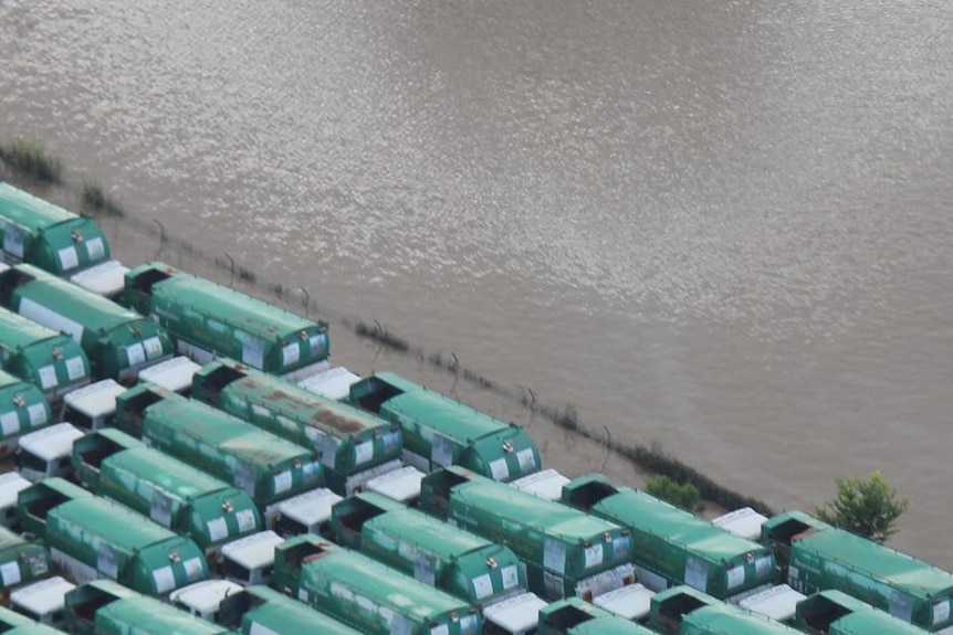 Garbage trucks submerged in floodwaters at Rocklea