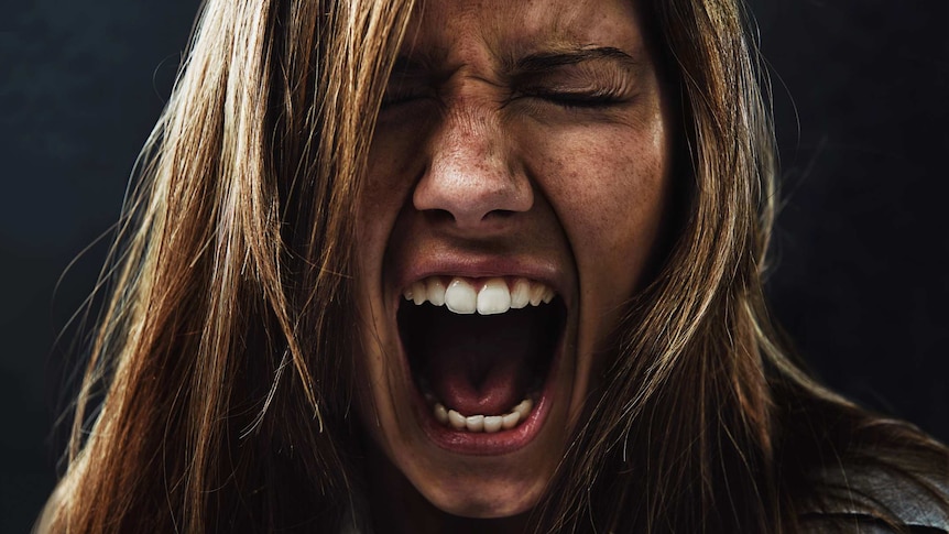 Close up of woman's face in a silent scream.