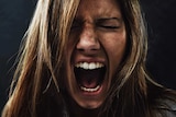 Close up of woman's face in a silent scream.
