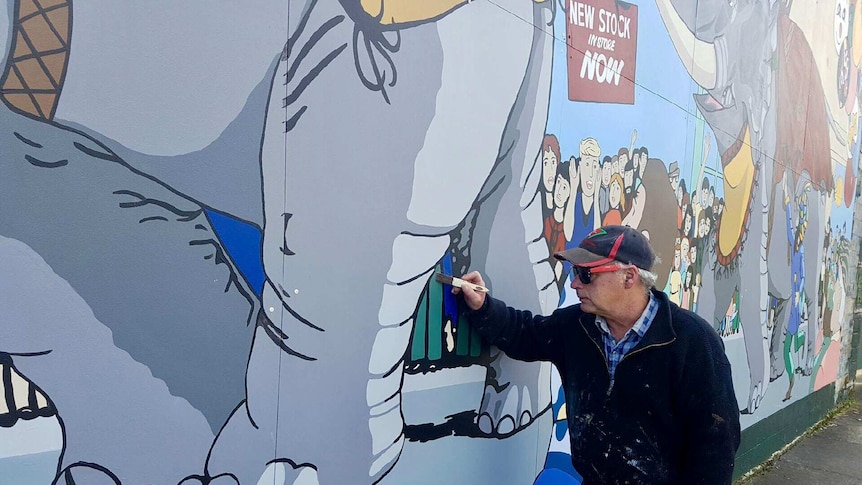 Mural restorer Julian Bale with the Great Elephant Race mural