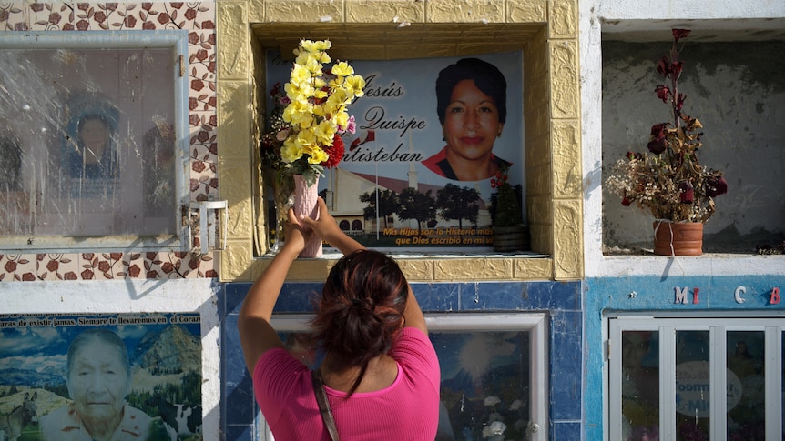 A woman puts flowers in a columbarium box to honour her dead aunt.