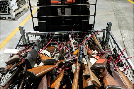 a trolley full to the brim with rifles