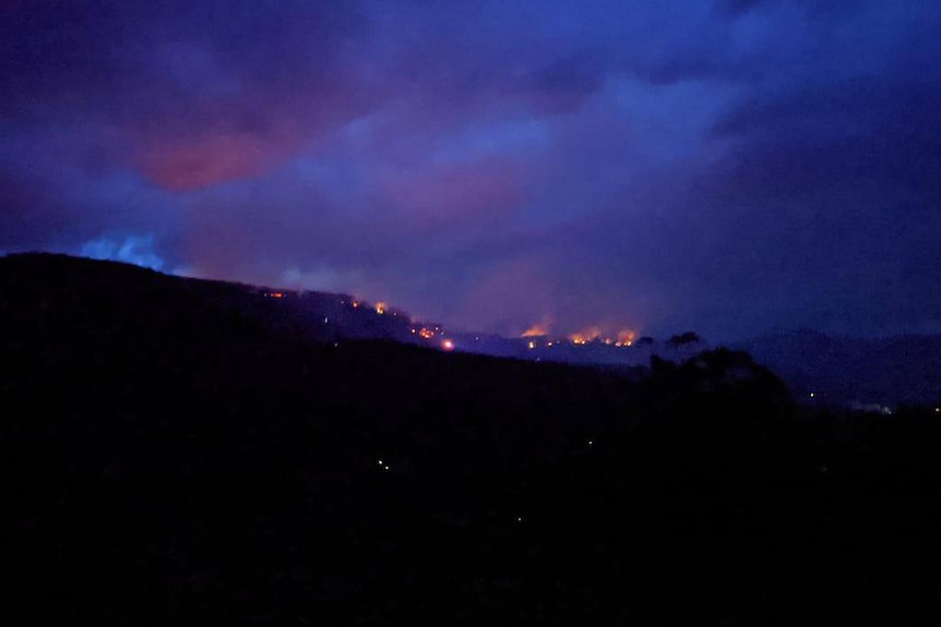 Orange glow of a fire on the hills at Lachlan