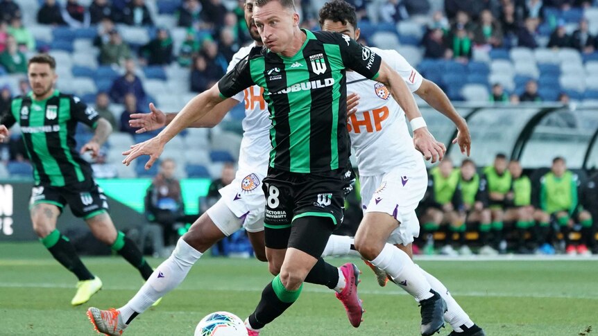 Besart Berisha runs with the ball at his feet wearing a green and black striped shirt