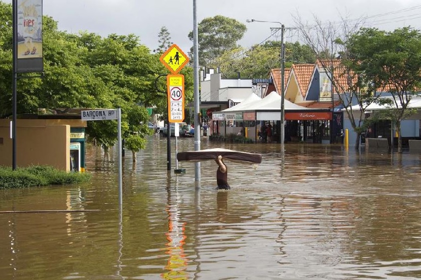 A man carries a mattress through floodwaters in Baroona Road at Rosalie Village in Brisbane, January 12, 2011.