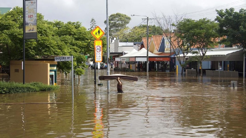 A man carries a mattress through floodwaters in Baroona Road at Rosalie Village in Brisbane, January 12, 2011.