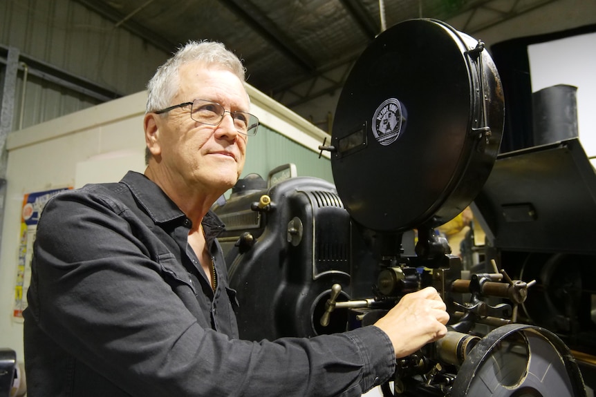 A man with an old cinema projector