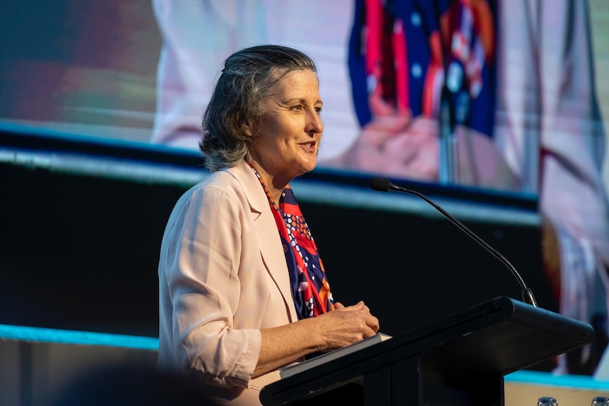 Fiona Guthrie speaks as she stands at a lectern addressing a conference.