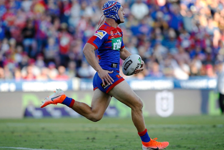 Kalyn Ponga running the ball in his left hand as he heads towards the try line.