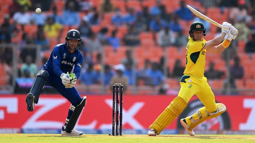 An Australian batter plays a shot as England's wicketkeeper looks on during the men's Cricket World Cup.