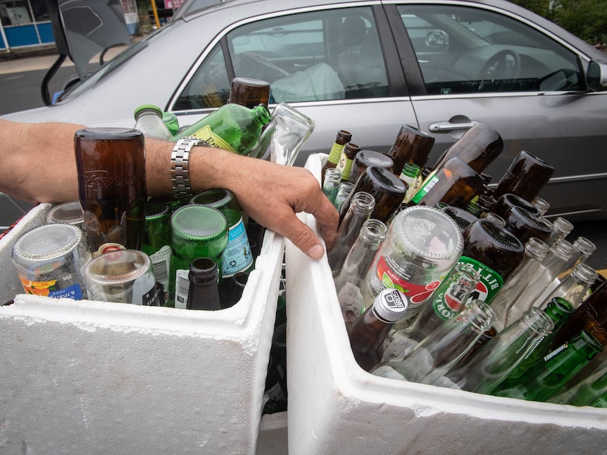 Two large containers of glasses collected to be exchanged for cash at the NSW return and earn reverse vending machine.