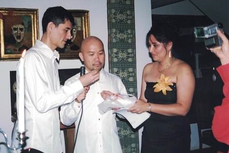 A woman handing a ring to two men during a commitment ceremony