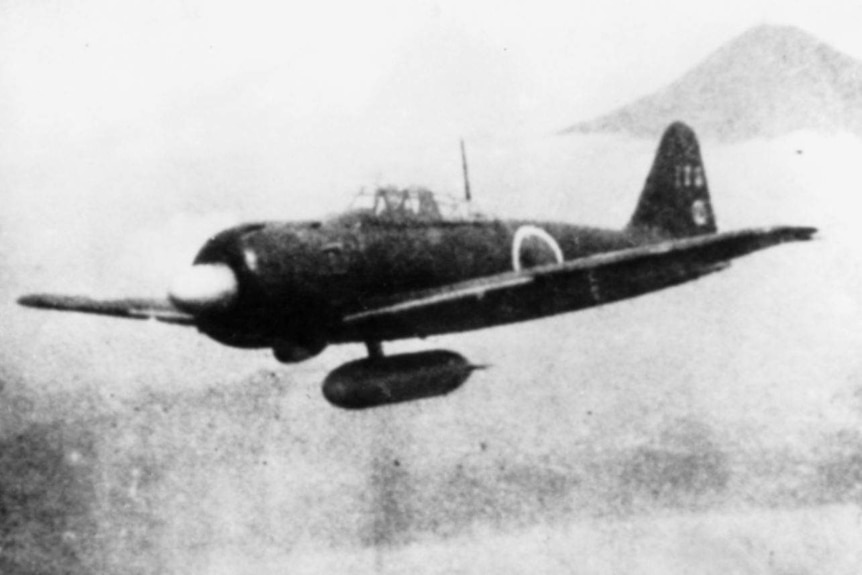 A grainy black and white photo of an airborne fighter plane.