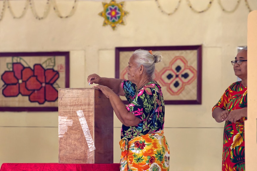 A woman placing her vote into a ballot box at a polling station on election day in Funafuti, the capital of Tuvalu.