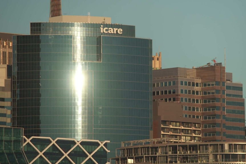 Afternoon sun reflecting of the windows of a building with an icare at the top.