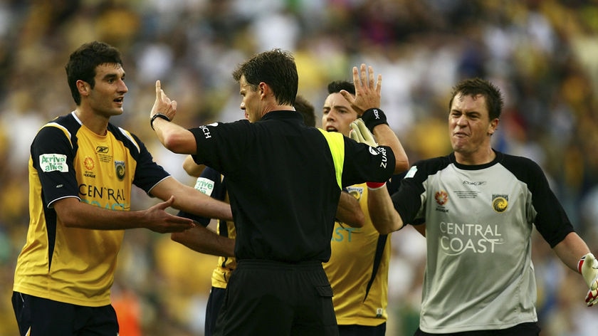 Danny Vukovic (right) strikes referee Mark Shield on the hand in the dying minutes of the A-League Grand Final on Sunday night.