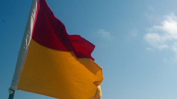 Generic surf lifesaving flag against a blue sky