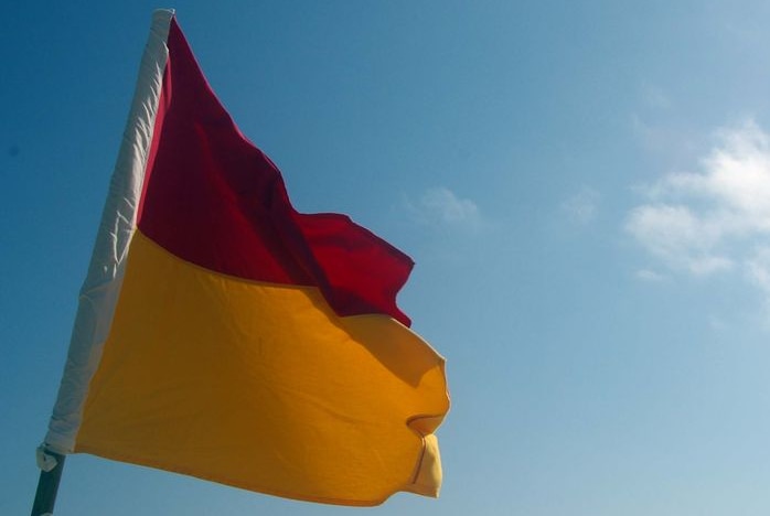 Generic surf lifesaving flag against a blue sky