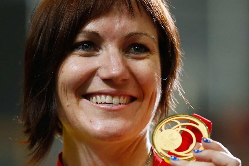 Anna Meares celebrates on the podium after winning the gold medal in the women's 500m time-trial at Glasgow 2014