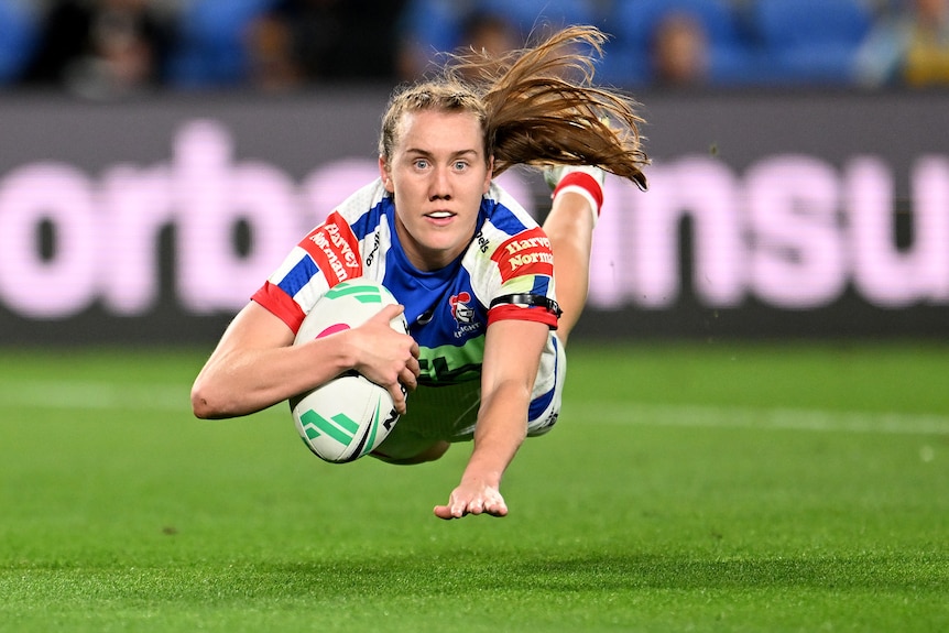 A Newcastle Knights NRLW player dives to score a try.